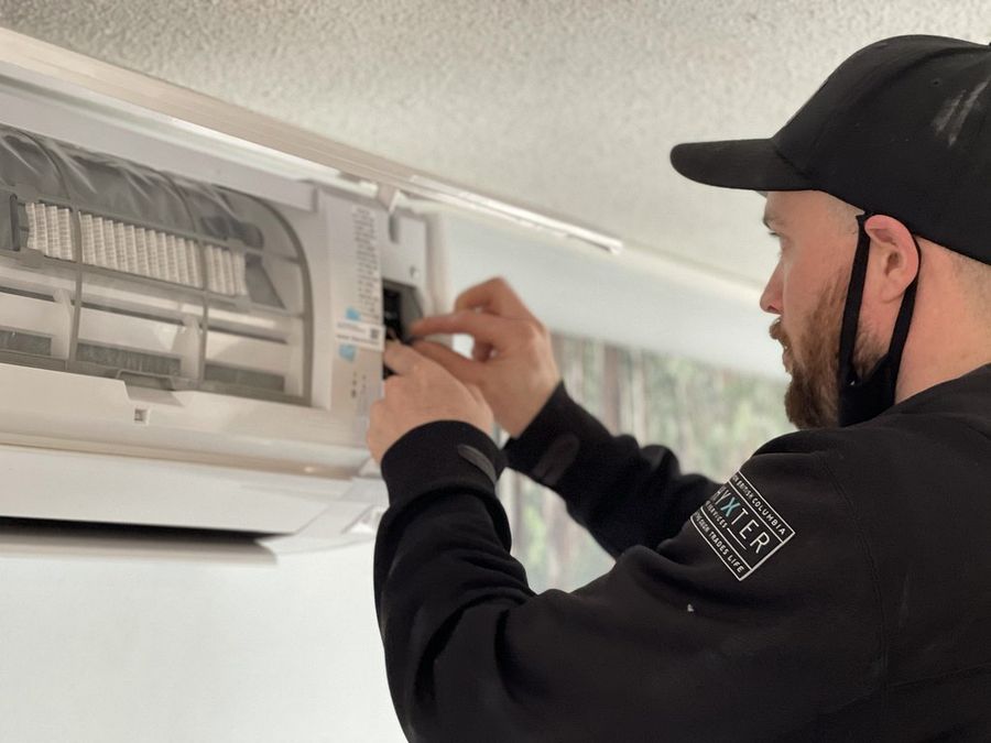 Technician servicing a wall-mounted split AC indoor unit in Doha
