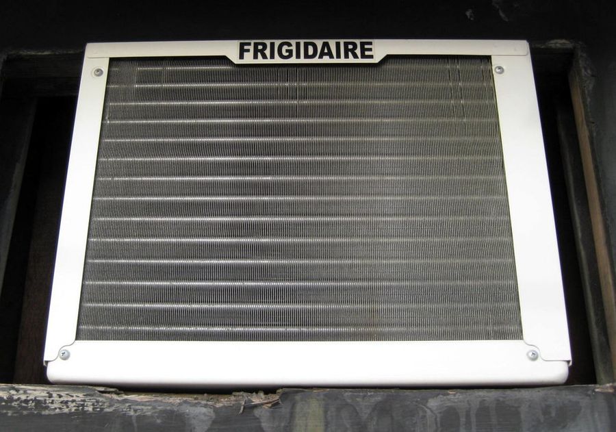 Window AC condenser coil exposed for cleaning and inspection